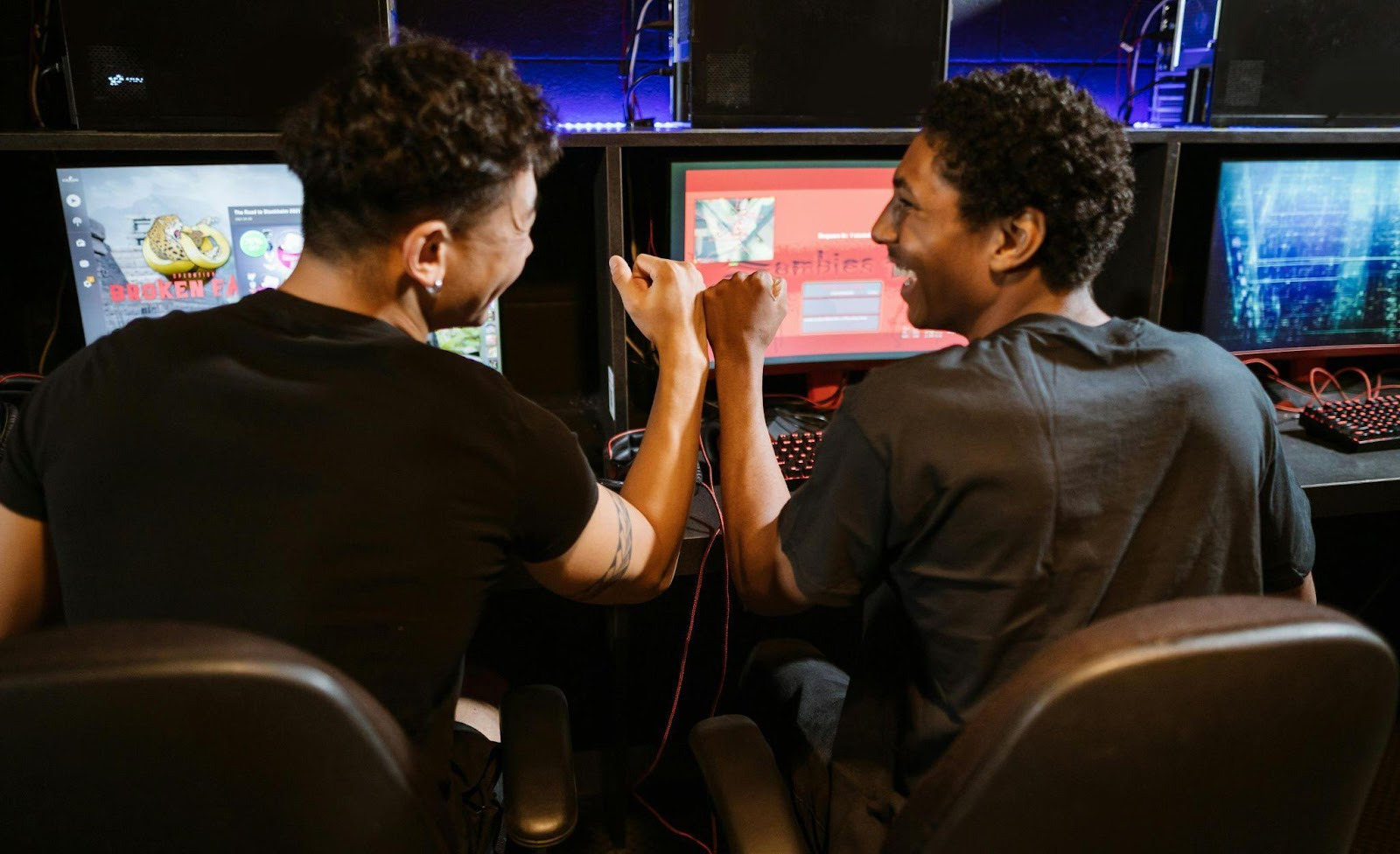 Two gamers celebrating at computers.